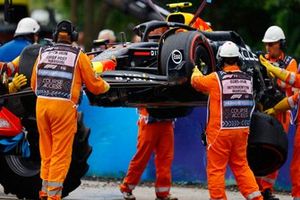 Los comisarios retiran el coche dañado de Sergio Pérez, Red Bull Racing RB20