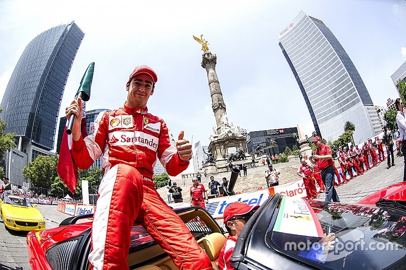 Esteban Guti&eacute;rrez con una bandera de M&eacute;xico festeja en la columna del Angel de la Independencia durante Scuderia Ferrari Street Demo en la Ciudad de M&eacute;xico