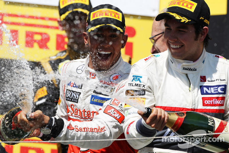 Race winner Lewis Hamilton, McLaren Mercedes celebrates on the podium with Sergio Perez, Sauber