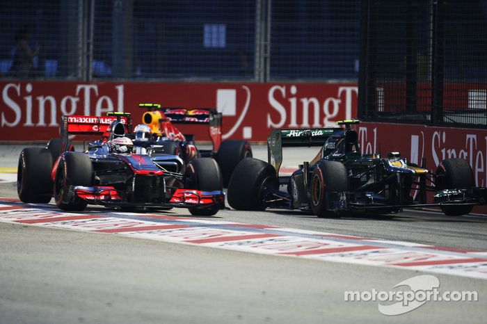 Lewis Hamilton, McLaren y Mark Webber, Red Bull Racing pasean el Caterham chocado de Vitaly Petrov, 