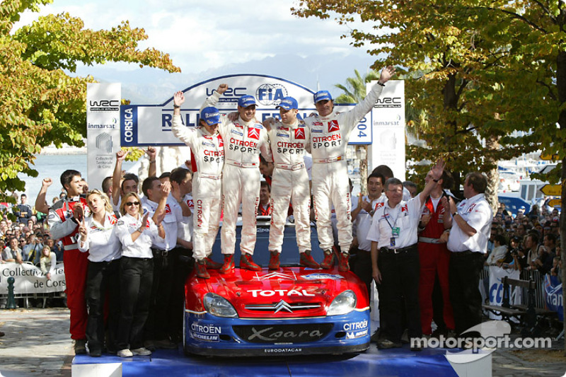 Podio: campeones del mundo del WRC 2004 Sébastien Loeb y Daniel Elena con Carlos Sainz y Marc Marti