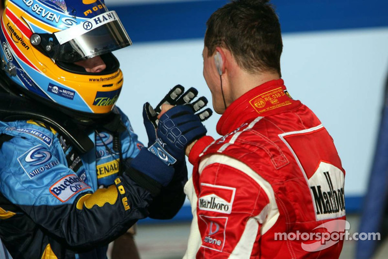 Race winner Fernando Alonso congratulated by Michael Schumacher