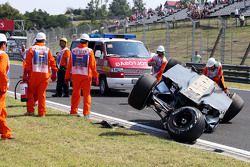 Oficiales de seguridad atienden al accidentado Sahara Force India de Sergio Pérez.