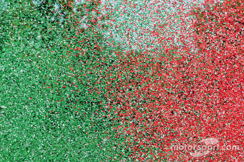Miles de papelitos con los colores de la badera de italia en el podio 