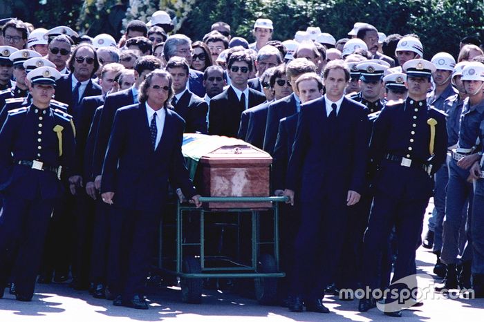 Emerson Fittipaldi, Jackie Stewart, Johnny Herbert, Derek Warwick, Gerhard Berger, Rubens Barrichello, Thierry Boutsen, Alain Prost e Damon Hill ajudam a carregar o caixão de Ayrton Senna durante seu funeral