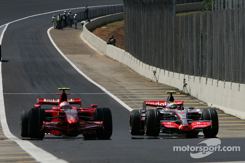 Kimi Raikkonen, Scuderia Ferrari dépasse Lewis Hamilton, McLaren Mercedes dans l'entrée des stands