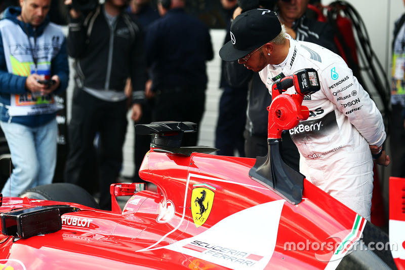 Lewis Hamilton, Mercedes AMG F1 looks at the Ferrari SF15-T of Sebastian Vettel, Ferrari in parc ferme