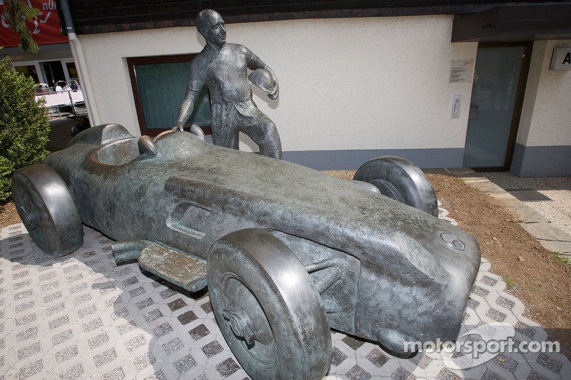 Una estatua de bronce de Juan Manuel Fangio y su Mercedes-Benz W196 en la entrada de la pista