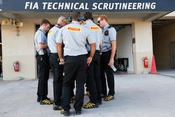 Des ingénieurs Pirelli devant le garage de la FIA