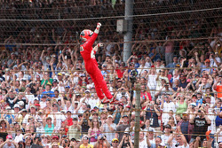 Race winner Helio Castroneves climbs the fence